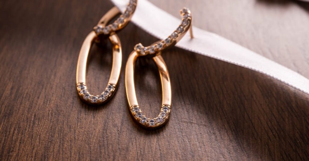 Close-up of gold hoop earrings with diamonds on wood and ribbon background.
